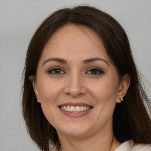 Joyful white adult female with long  brown hair and brown eyes