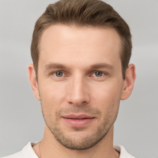 Joyful white young-adult male with short  brown hair and grey eyes