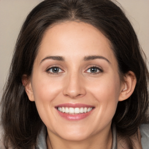 Joyful white young-adult female with long  brown hair and brown eyes