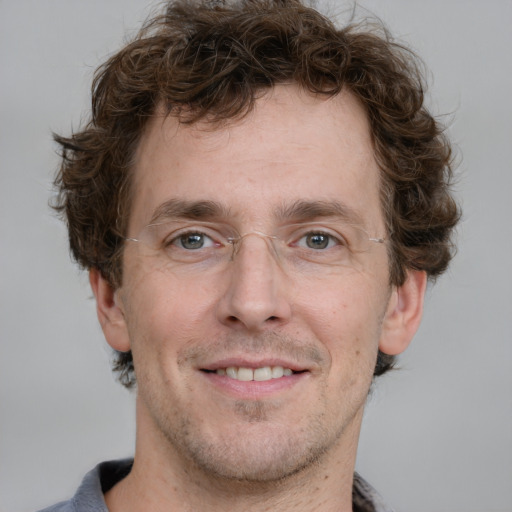 Joyful white adult male with short  brown hair and grey eyes