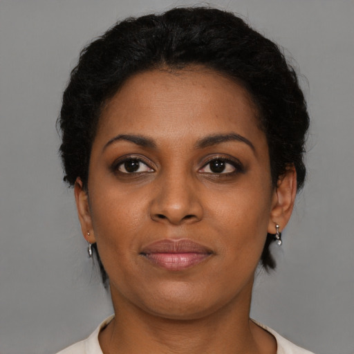 Joyful black young-adult female with short  brown hair and brown eyes