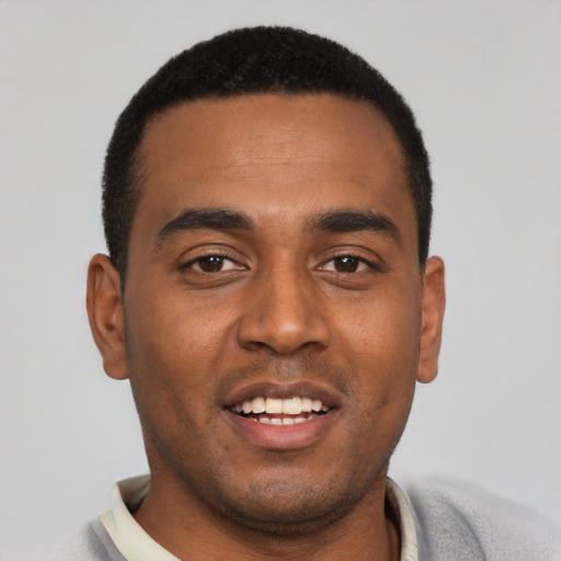 Joyful black young-adult male with short  black hair and brown eyes