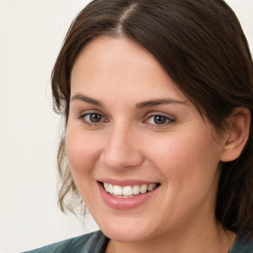 Joyful white young-adult female with medium  brown hair and grey eyes