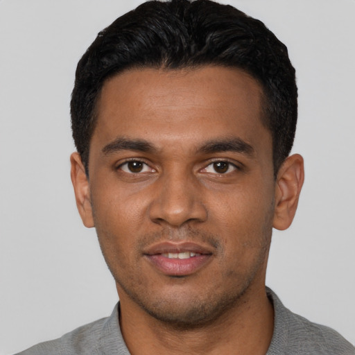 Joyful black young-adult male with short  black hair and brown eyes
