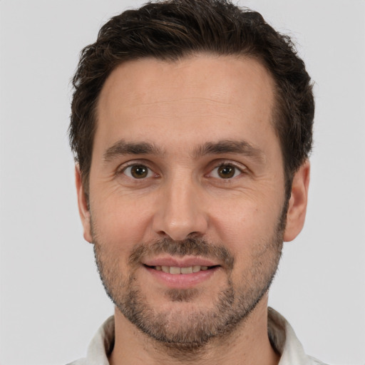 Joyful white adult male with short  brown hair and brown eyes