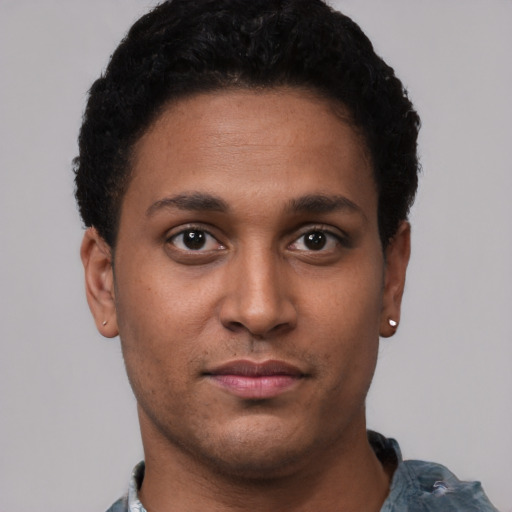 Joyful latino young-adult male with short  brown hair and brown eyes