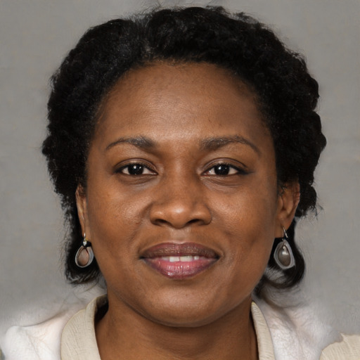 Joyful black adult female with short  brown hair and brown eyes