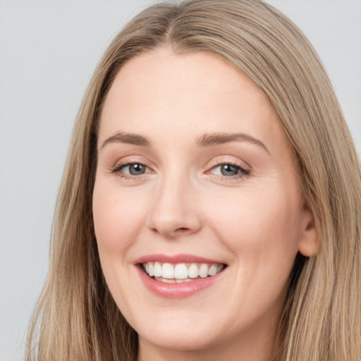 Joyful white young-adult female with long  brown hair and grey eyes