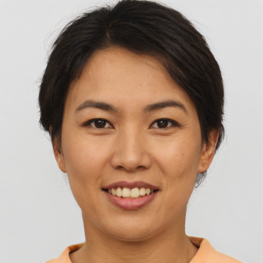 Joyful asian young-adult female with short  brown hair and brown eyes