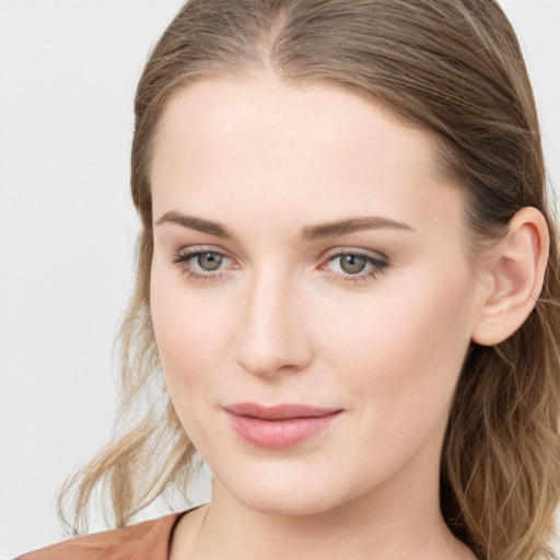 Joyful white young-adult female with long  brown hair and blue eyes