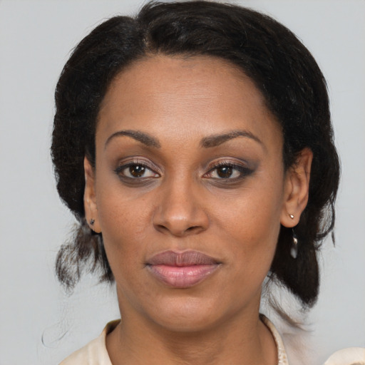 Joyful black adult female with medium  brown hair and brown eyes