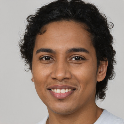 Joyful latino young-adult male with short  brown hair and brown eyes