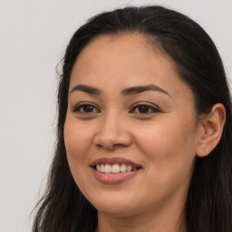 Joyful latino young-adult female with long  brown hair and brown eyes