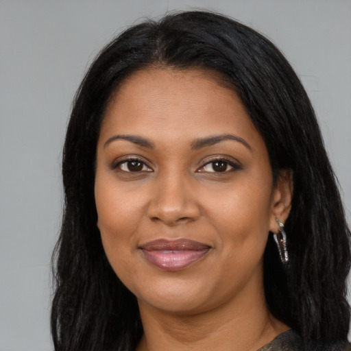 Joyful black adult female with long  brown hair and brown eyes
