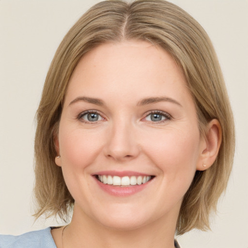 Joyful white young-adult female with medium  brown hair and green eyes