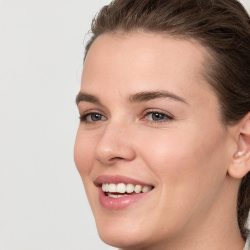 Joyful white young-adult female with medium  brown hair and grey eyes