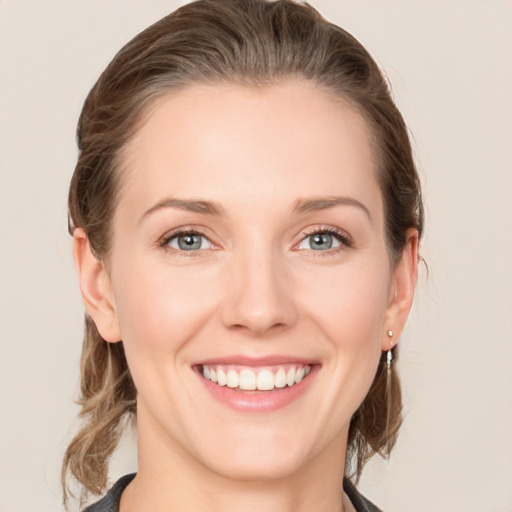 Joyful white young-adult female with medium  brown hair and grey eyes