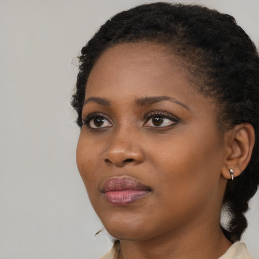 Joyful black young-adult female with medium  black hair and brown eyes