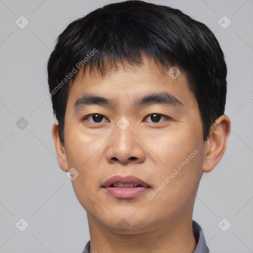 Joyful asian young-adult male with short  black hair and brown eyes