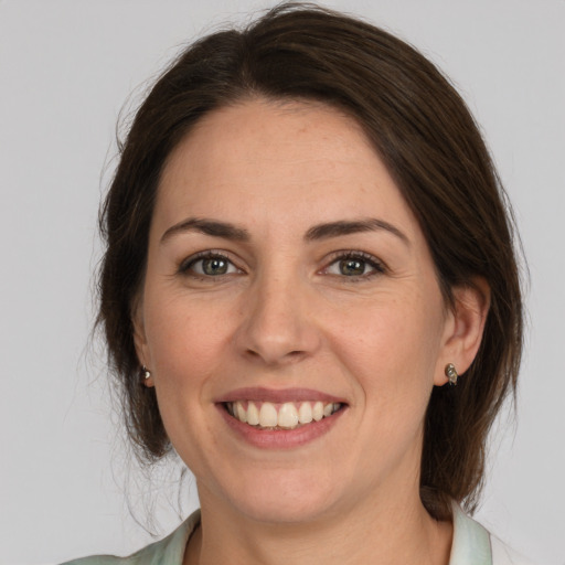 Joyful white adult female with medium  brown hair and brown eyes