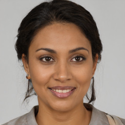 Joyful latino young-adult female with medium  brown hair and brown eyes