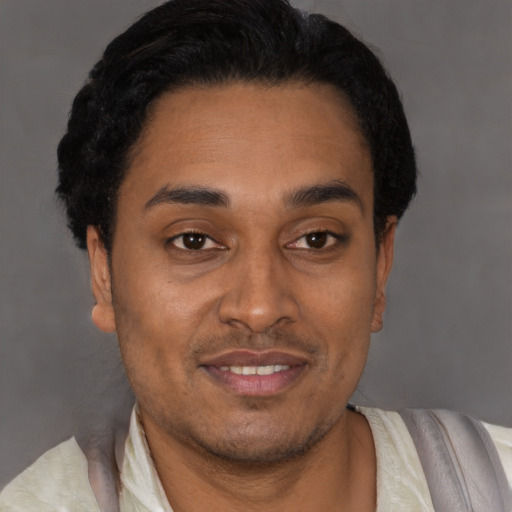 Joyful latino young-adult male with short  black hair and brown eyes