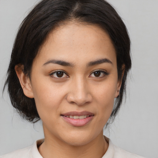 Joyful latino young-adult female with medium  brown hair and brown eyes