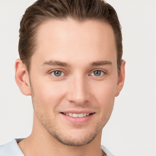 Joyful white young-adult male with short  brown hair and grey eyes