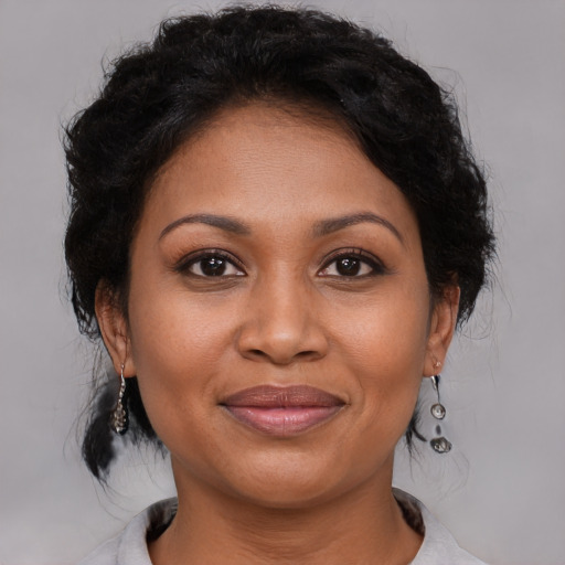 Joyful black adult female with medium  brown hair and brown eyes