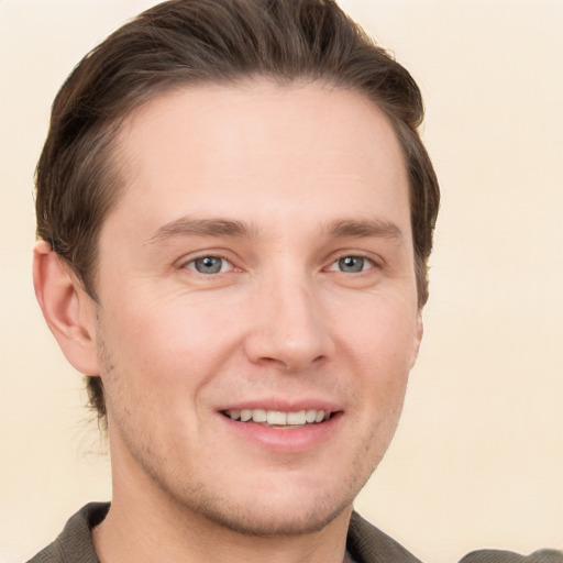 Joyful white young-adult male with short  brown hair and grey eyes