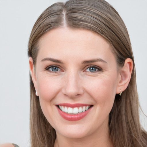 Joyful white young-adult female with long  brown hair and grey eyes