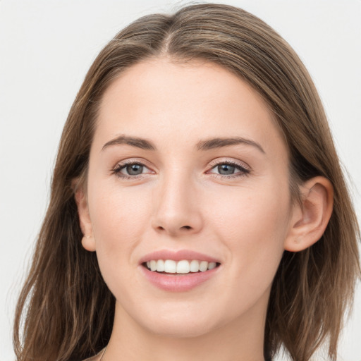 Joyful white young-adult female with long  brown hair and grey eyes