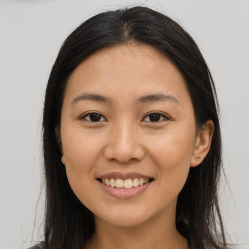 Joyful asian young-adult female with long  brown hair and brown eyes