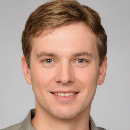 Joyful white young-adult male with short  brown hair and grey eyes