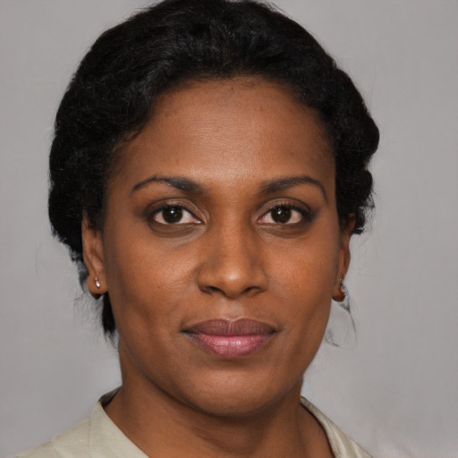Joyful black young-adult female with short  black hair and brown eyes