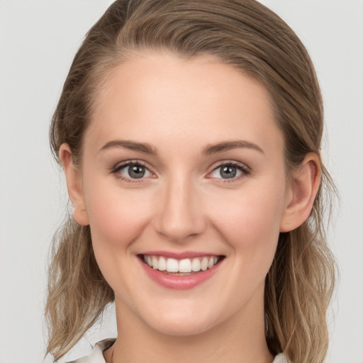 Joyful white young-adult female with medium  brown hair and grey eyes