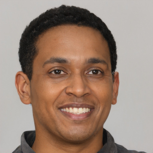 Joyful latino adult male with short  brown hair and brown eyes