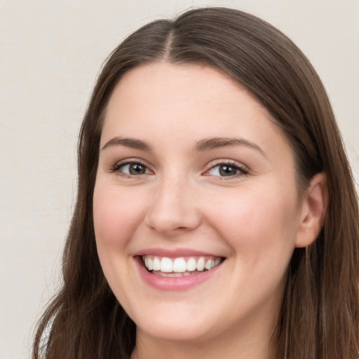 Joyful white young-adult female with long  brown hair and grey eyes