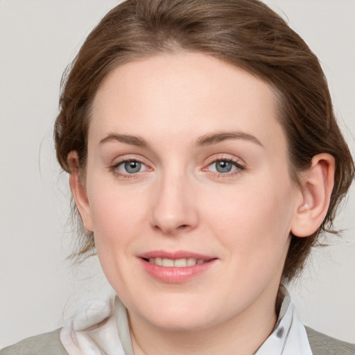 Joyful white young-adult female with medium  brown hair and blue eyes