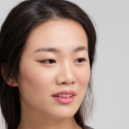 Joyful asian young-adult female with long  brown hair and brown eyes