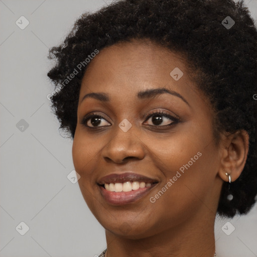 Joyful black young-adult female with long  brown hair and brown eyes