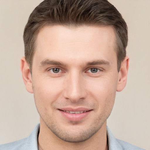 Joyful white young-adult male with short  brown hair and grey eyes