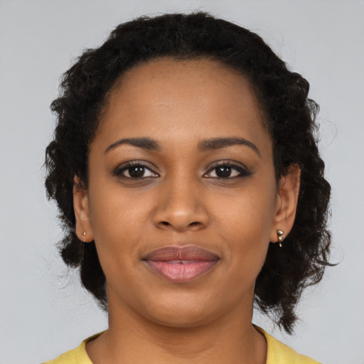 Joyful black young-adult female with short  black hair and brown eyes
