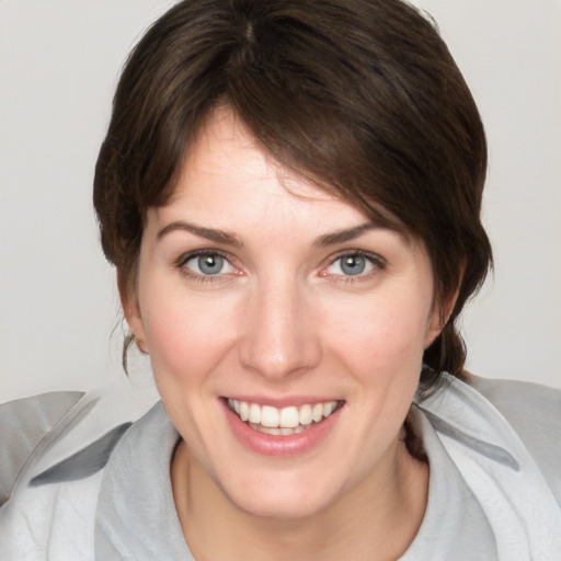 Joyful white young-adult female with medium  brown hair and blue eyes