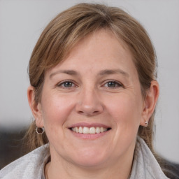 Joyful white adult female with medium  brown hair and grey eyes