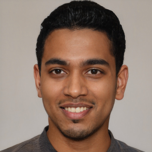 Joyful latino young-adult male with short  black hair and brown eyes