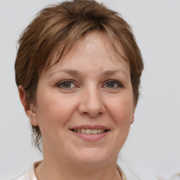 Joyful white adult female with medium  brown hair and grey eyes