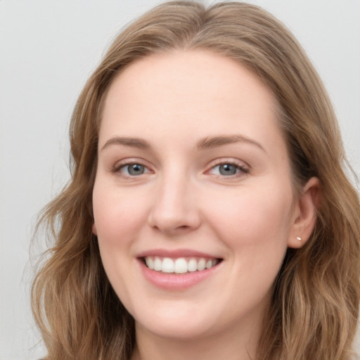 Joyful white young-adult female with long  brown hair and blue eyes