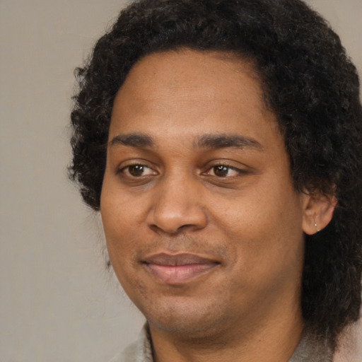 Joyful black adult male with short  brown hair and brown eyes