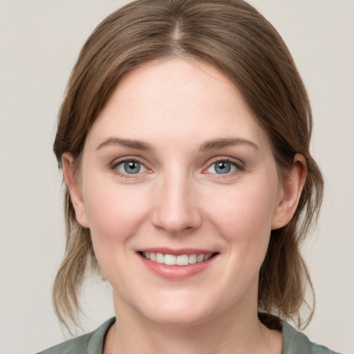 Joyful white young-adult female with medium  brown hair and grey eyes